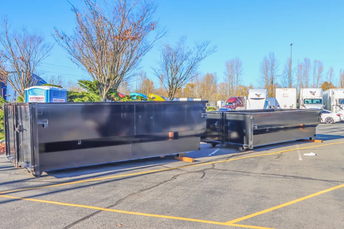 Professional dumpster rental service with roll-off container on residential driveway in Sandpoint